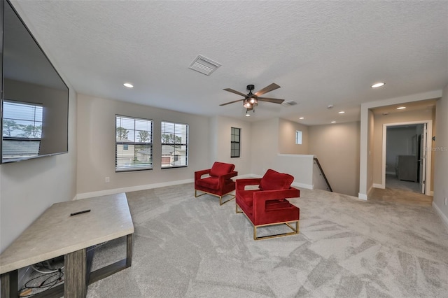 sitting room featuring carpet flooring, visible vents, and an upstairs landing