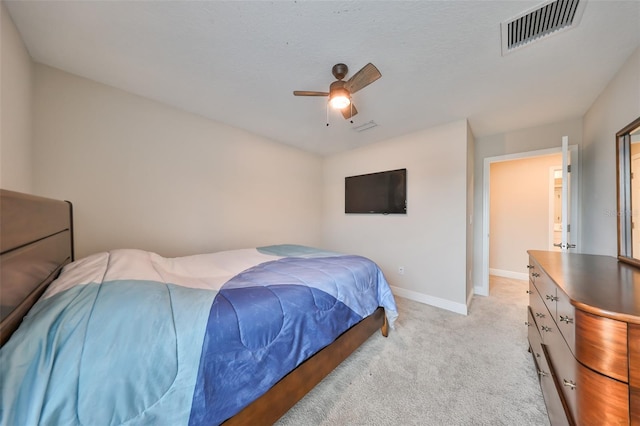 bedroom with light carpet, ceiling fan, visible vents, and baseboards