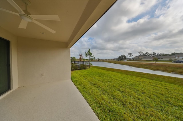 view of yard featuring a water view and ceiling fan