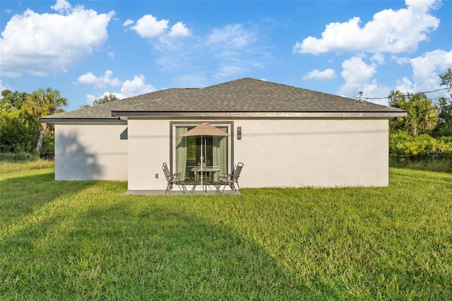 rear view of house featuring a lawn and a patio area