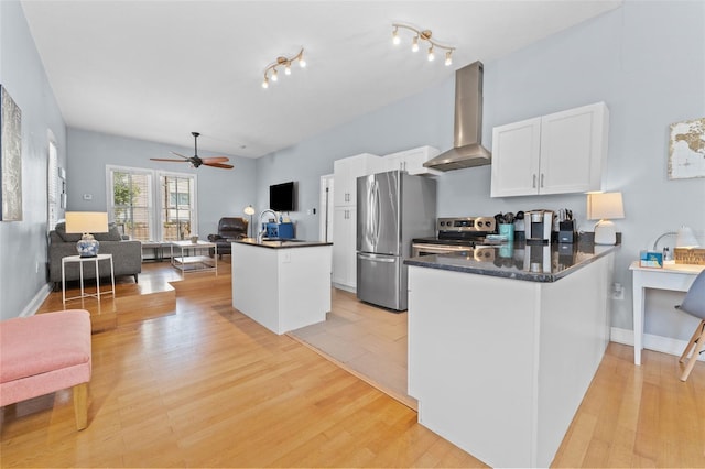 408 E Amelia Ave, Tampa, FL 33602 - kitchen featuring light wood finished floors, white cabinets, exhaust hood, ceiling fan, and appliances with stainless steel finishes