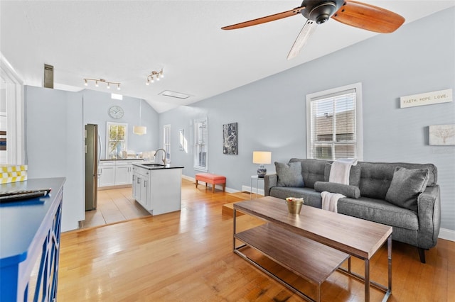 408 E Amelia Ave, Tampa, FL 33602 - living room with baseboards, ceiling fan, track lighting, vaulted ceiling, and light wood-type flooring