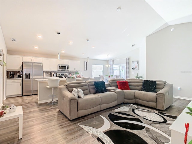 living room featuring light hardwood / wood-style flooring and lofted ceiling