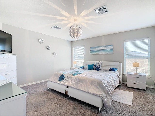 carpeted bedroom featuring an inviting chandelier