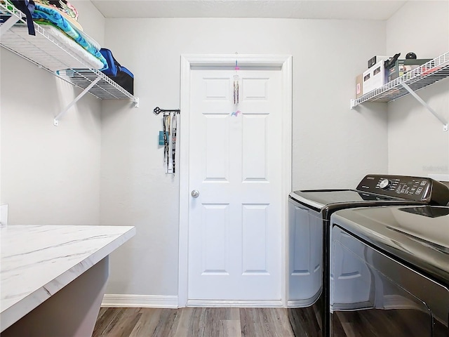 clothes washing area with independent washer and dryer and hardwood / wood-style flooring