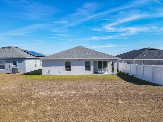 rear view of property with central air condition unit, a patio area, and a yard