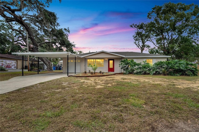 view of front of home with a carport and a lawn