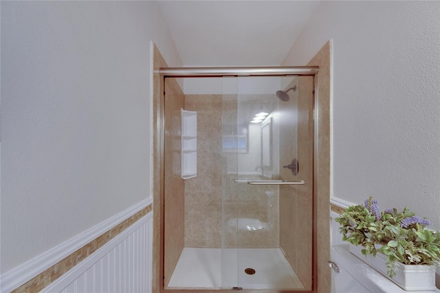 bathroom with a shower with door and toilet