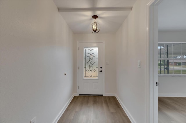 doorway to outside featuring light wood-type flooring and a notable chandelier