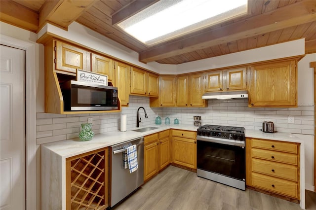 kitchen featuring sink, stainless steel appliances, light hardwood / wood-style flooring, beamed ceiling, and backsplash