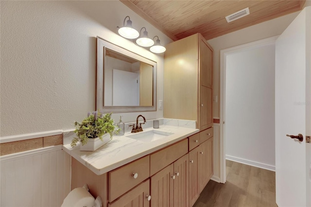 bathroom featuring hardwood / wood-style flooring, vanity, and wooden ceiling