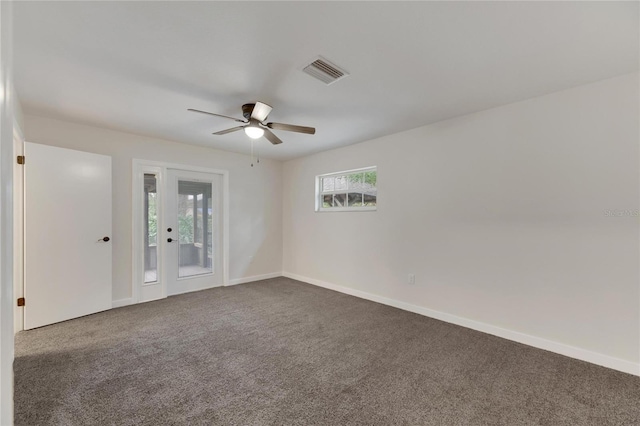 unfurnished room featuring dark colored carpet, ceiling fan, and a healthy amount of sunlight