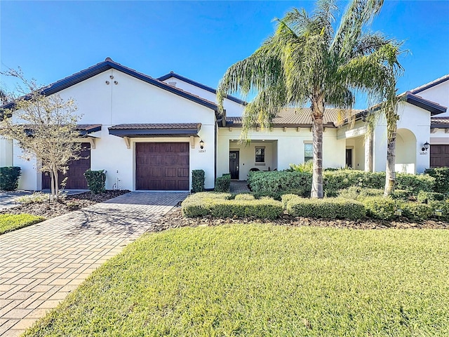 view of front of property with a garage and a front lawn