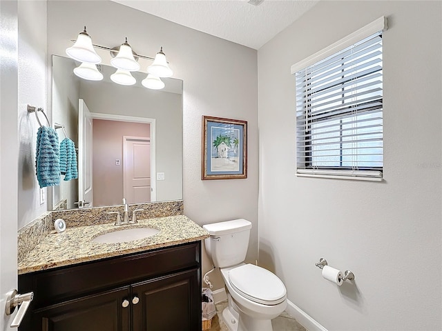 bathroom featuring a textured ceiling, vanity, and toilet