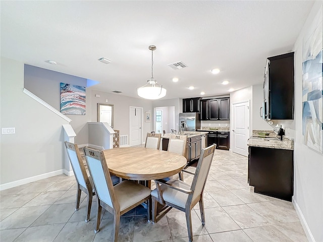 dining area with sink and light tile patterned flooring