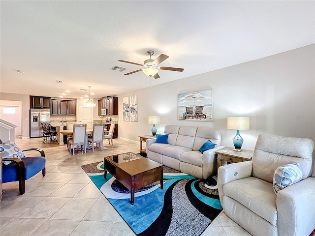 tiled living room featuring ceiling fan and sink