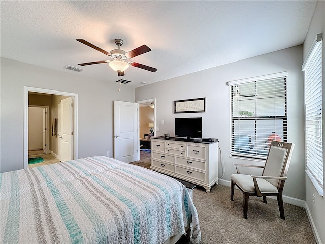 bedroom with a textured ceiling, light colored carpet, and ceiling fan