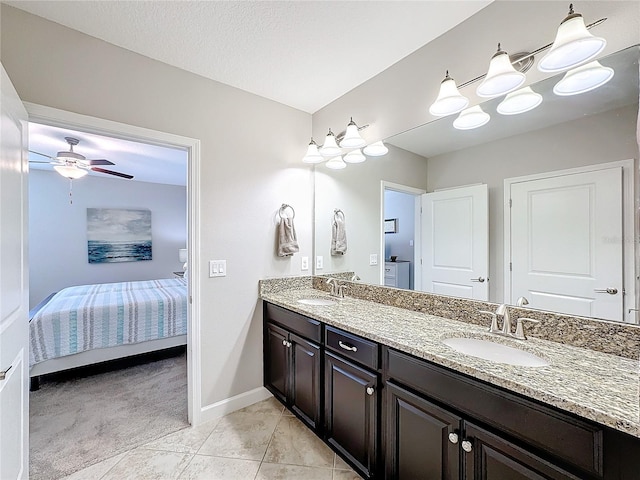 bathroom with tile patterned floors, ceiling fan, vanity, and a textured ceiling