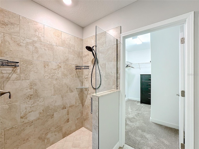 bathroom featuring a tile shower and a textured ceiling