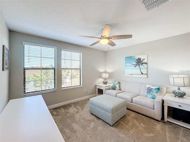 carpeted living room featuring a textured ceiling and ceiling fan