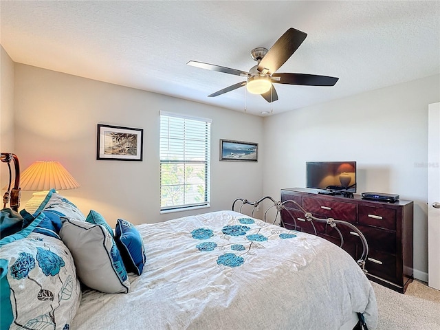 carpeted bedroom with ceiling fan and a textured ceiling