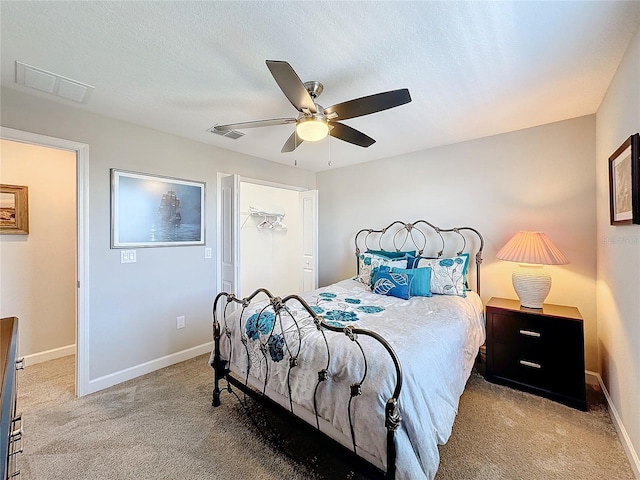 carpeted bedroom featuring ceiling fan and a textured ceiling