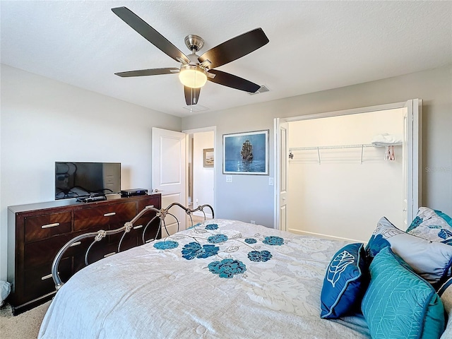 bedroom with ceiling fan, carpet floors, and a closet