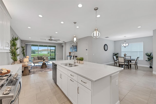 kitchen featuring light countertops, white cabinetry, a center island with sink, and a sink