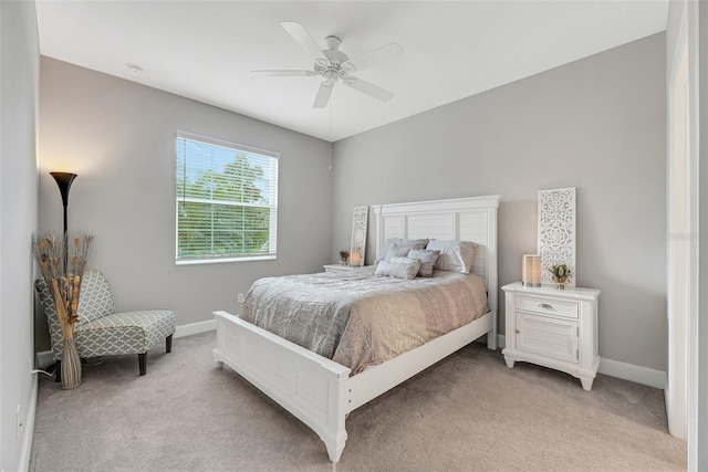 bedroom with baseboards, ceiling fan, and light colored carpet