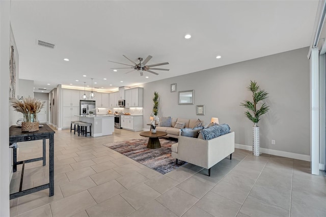 living room with recessed lighting, visible vents, ceiling fan, and baseboards