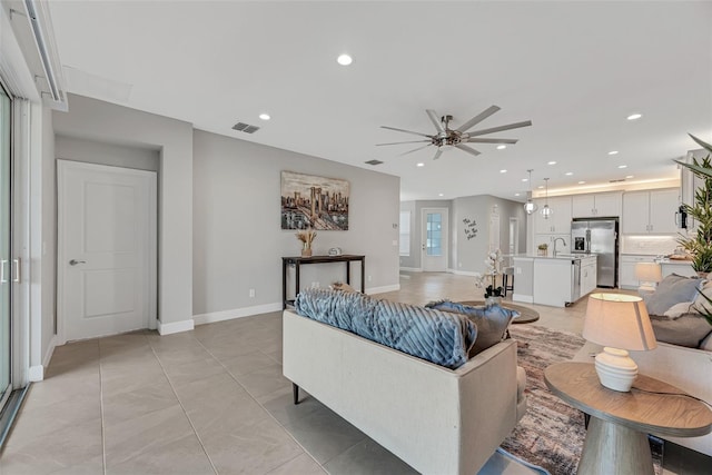 living room featuring ceiling fan, light tile patterned floors, recessed lighting, visible vents, and baseboards