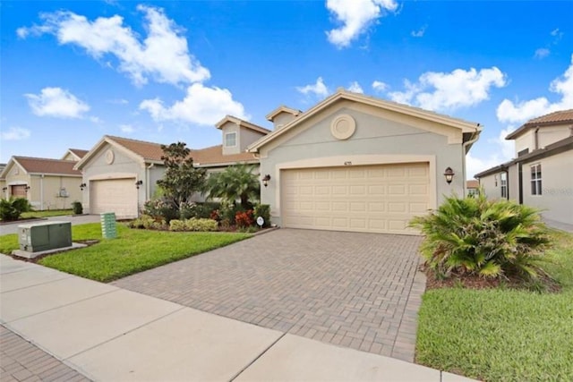 single story home with an attached garage, decorative driveway, a residential view, stucco siding, and a front lawn