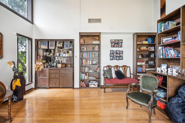 living area featuring a high ceiling and light wood-type flooring