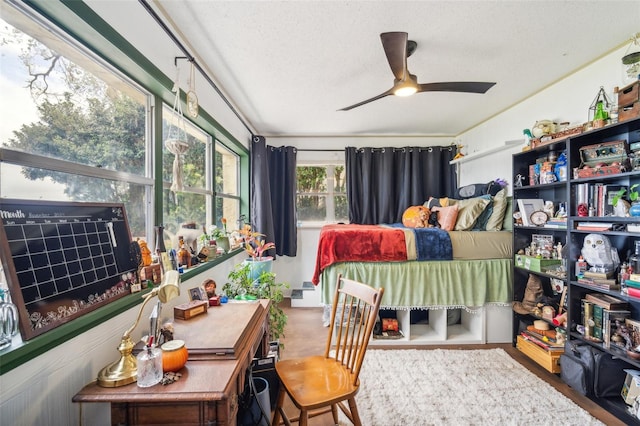 bedroom with wood-type flooring, a textured ceiling, and ceiling fan