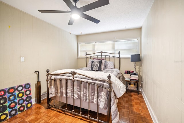 bedroom featuring ceiling fan, parquet floors, and a textured ceiling