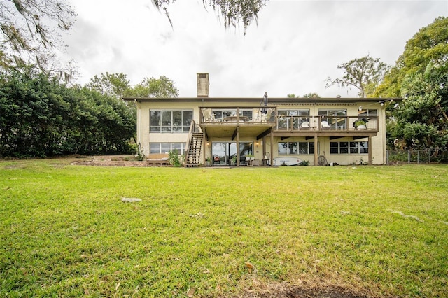 rear view of property featuring a yard and a deck