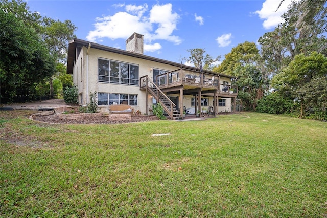 rear view of house featuring a deck and a lawn