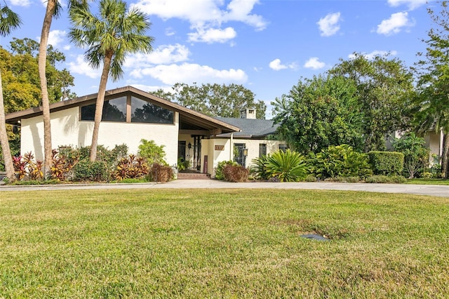 view of front facade with a front lawn and a carport