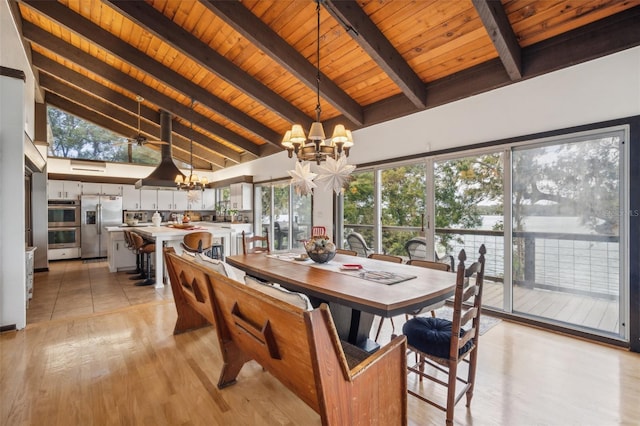 dining room featuring light hardwood / wood-style flooring, high vaulted ceiling, a chandelier, and plenty of natural light