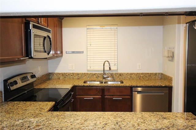 kitchen featuring light stone countertops, sink, and stainless steel appliances