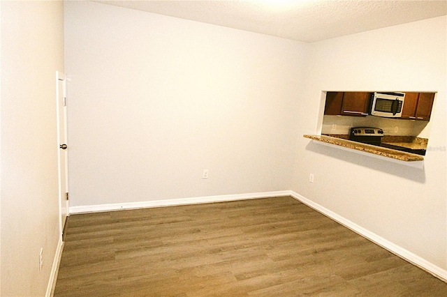 spare room featuring wood-type flooring and a textured ceiling