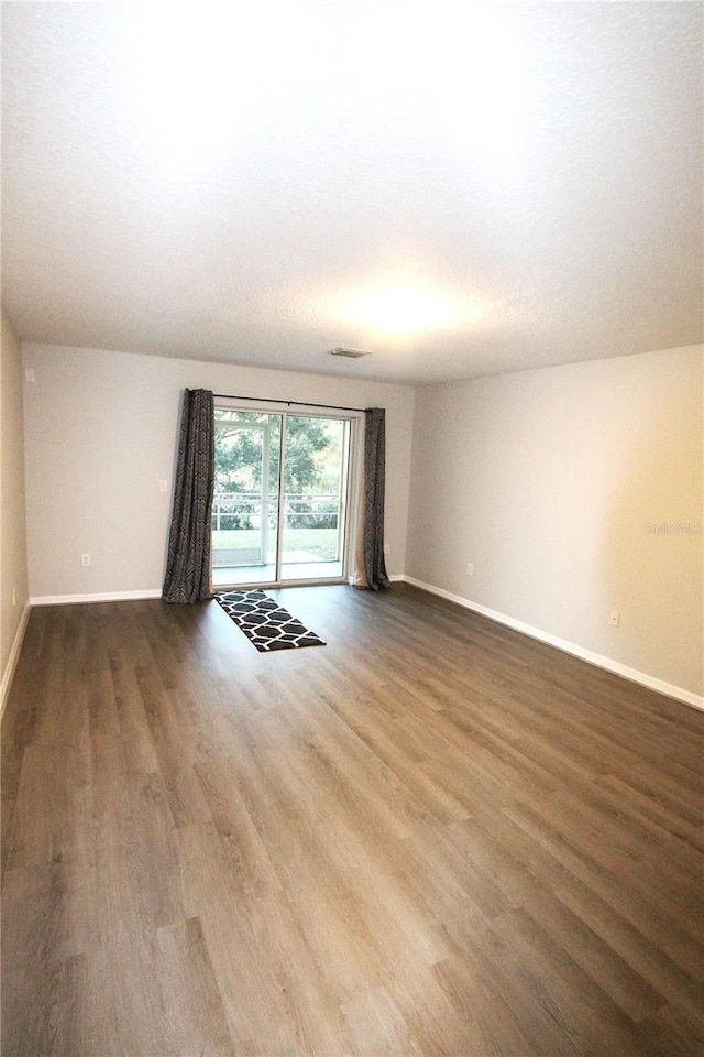 spare room with dark hardwood / wood-style floors