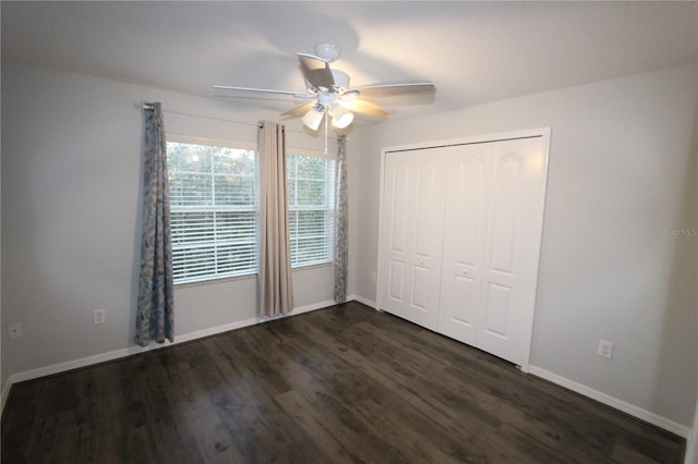 unfurnished bedroom with ceiling fan, a closet, and dark wood-type flooring