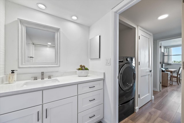 bathroom featuring vanity, wood-type flooring, and washer / clothes dryer