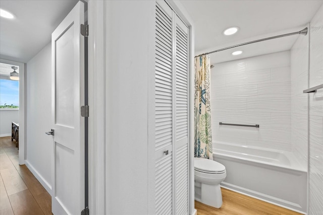 bathroom featuring shower / bath combo with shower curtain, hardwood / wood-style floors, and toilet