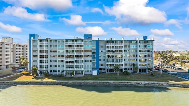 view of building exterior with a water view and a view of the beach