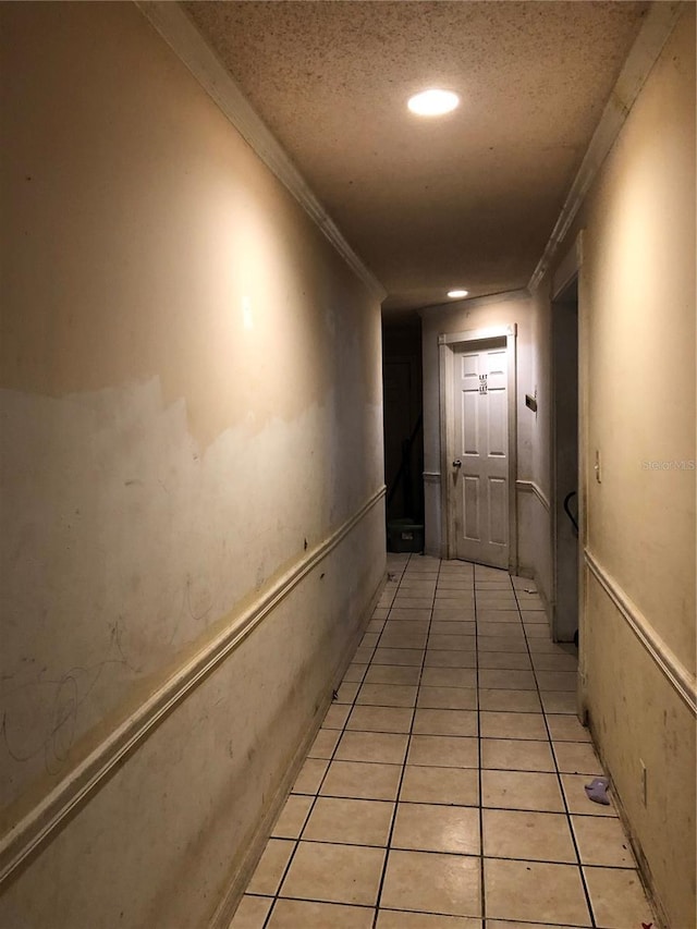 hallway featuring light tile patterned floors and crown molding