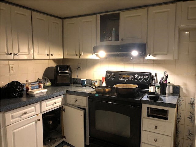 kitchen featuring white cabinets, black range with electric cooktop, tasteful backsplash, and exhaust hood