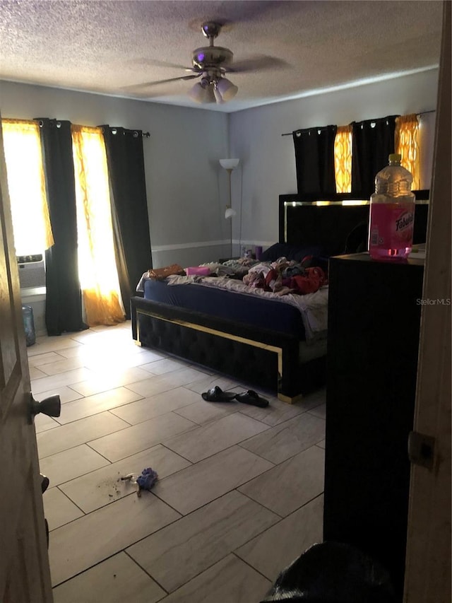 bedroom with ceiling fan and a textured ceiling