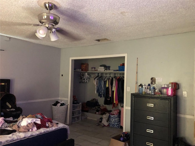 bedroom featuring ceiling fan, a textured ceiling, and a closet